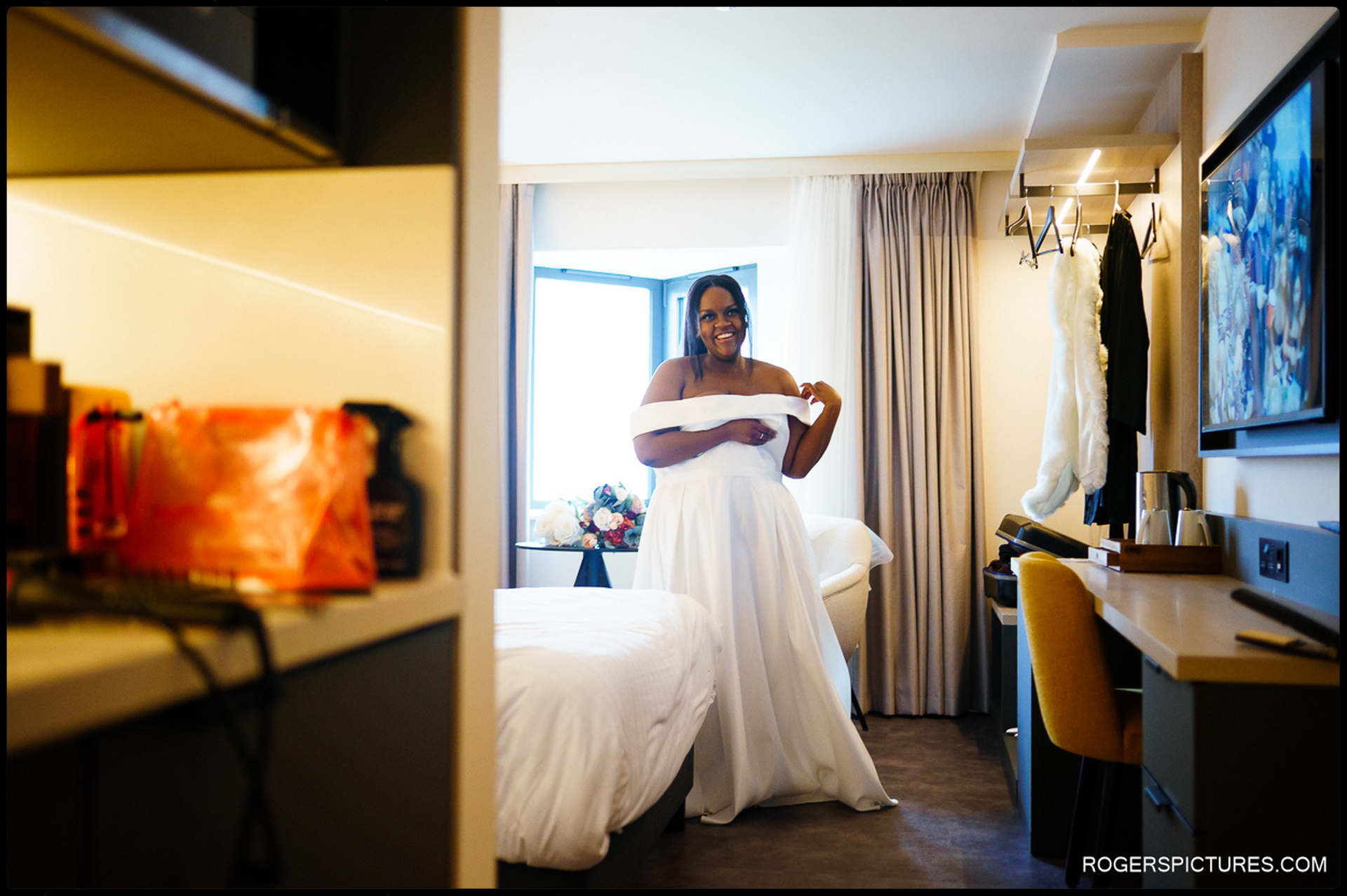 Bride smiling in her wedding dress during morning prep at the hotel