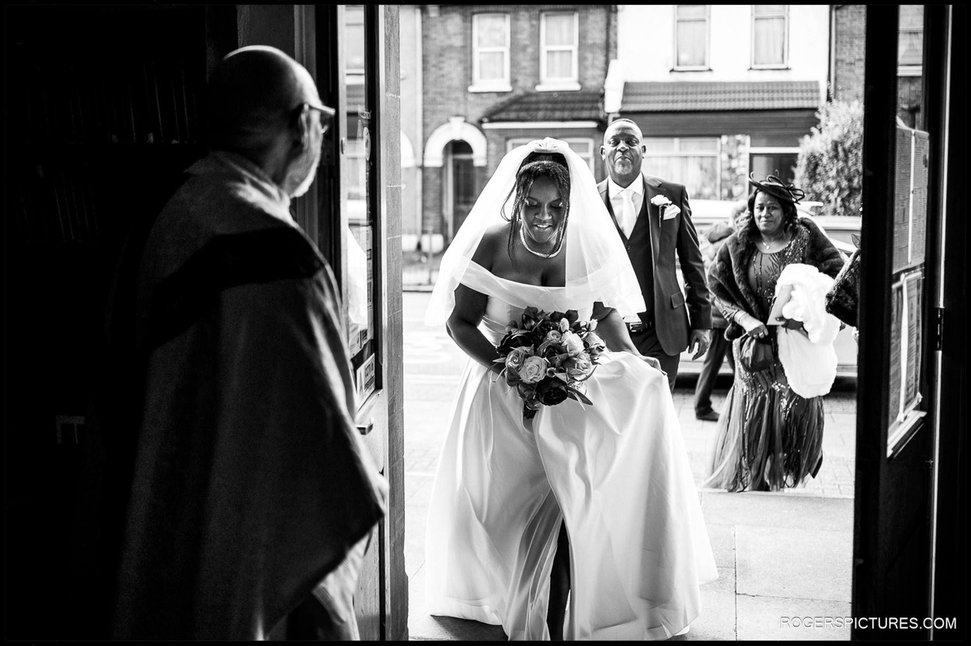 Bride arriving at church with her parents before the Catholic wedding ceremony