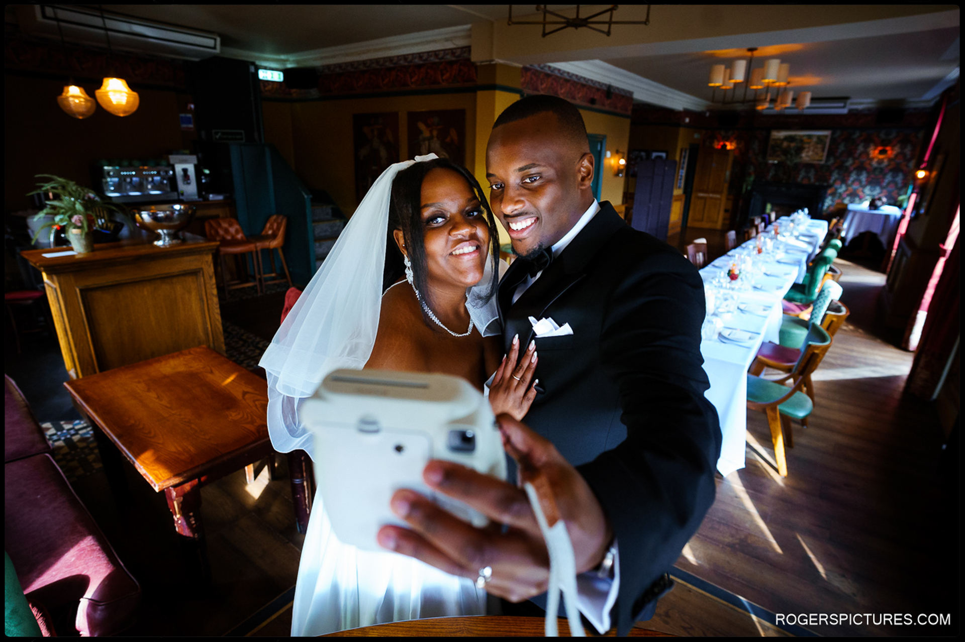 Newlyweds taking a selfie inside The King’s Head pub before the wedding reception