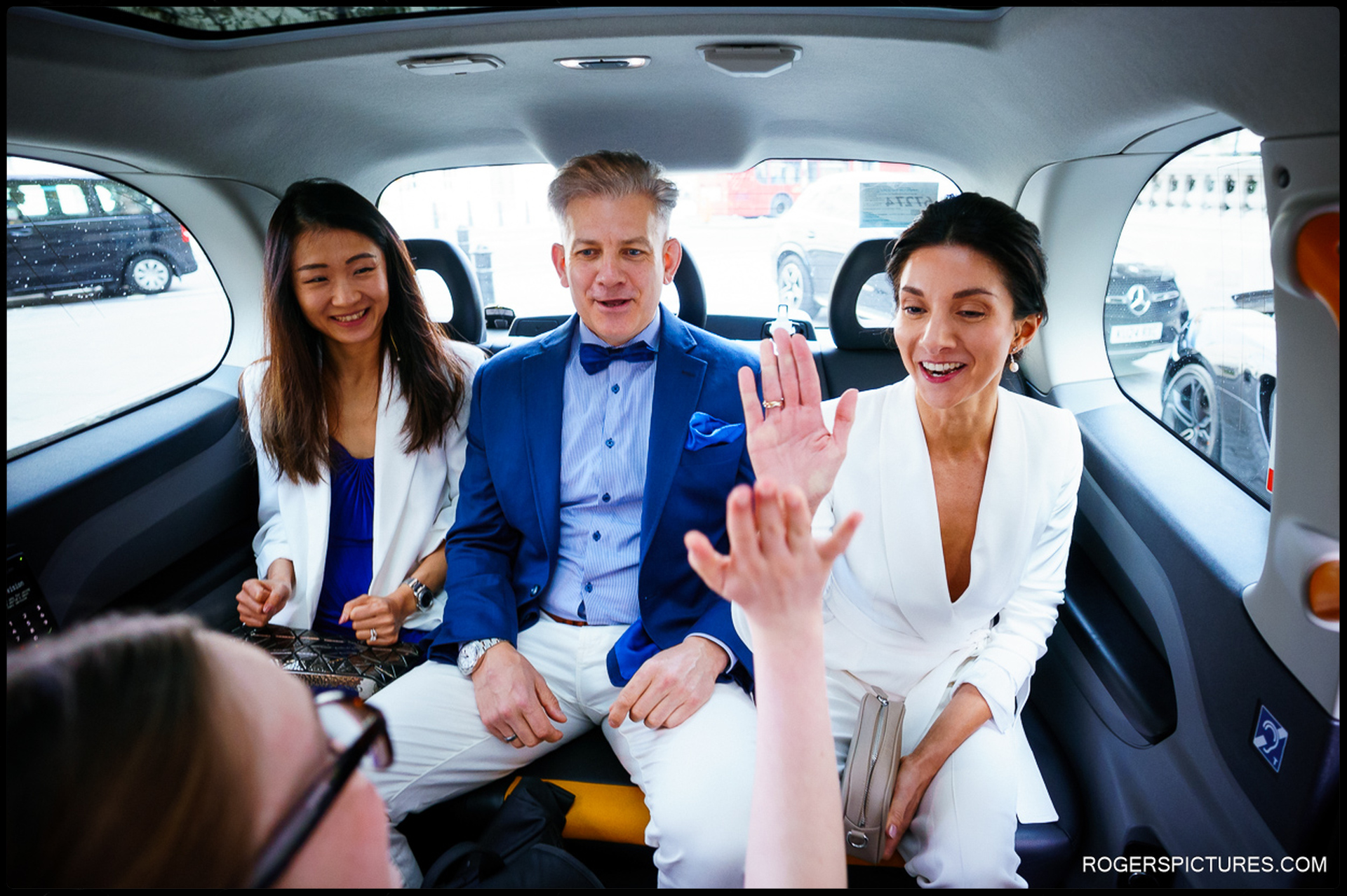 Bride and wedding party share a joyful moment in a London taxi en route to The Larrick.