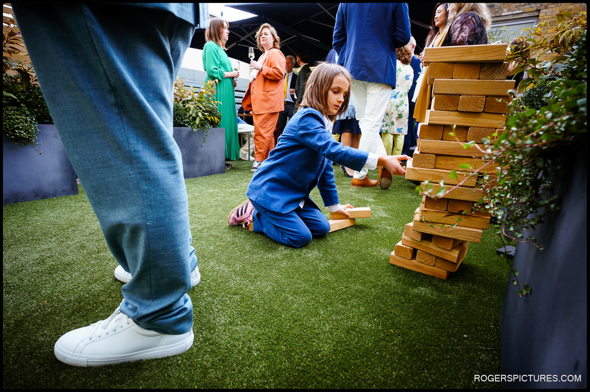 A young guest playing a giant Jenga game on the rooftop terrace during the wedding reception at 41 Portland Place.
