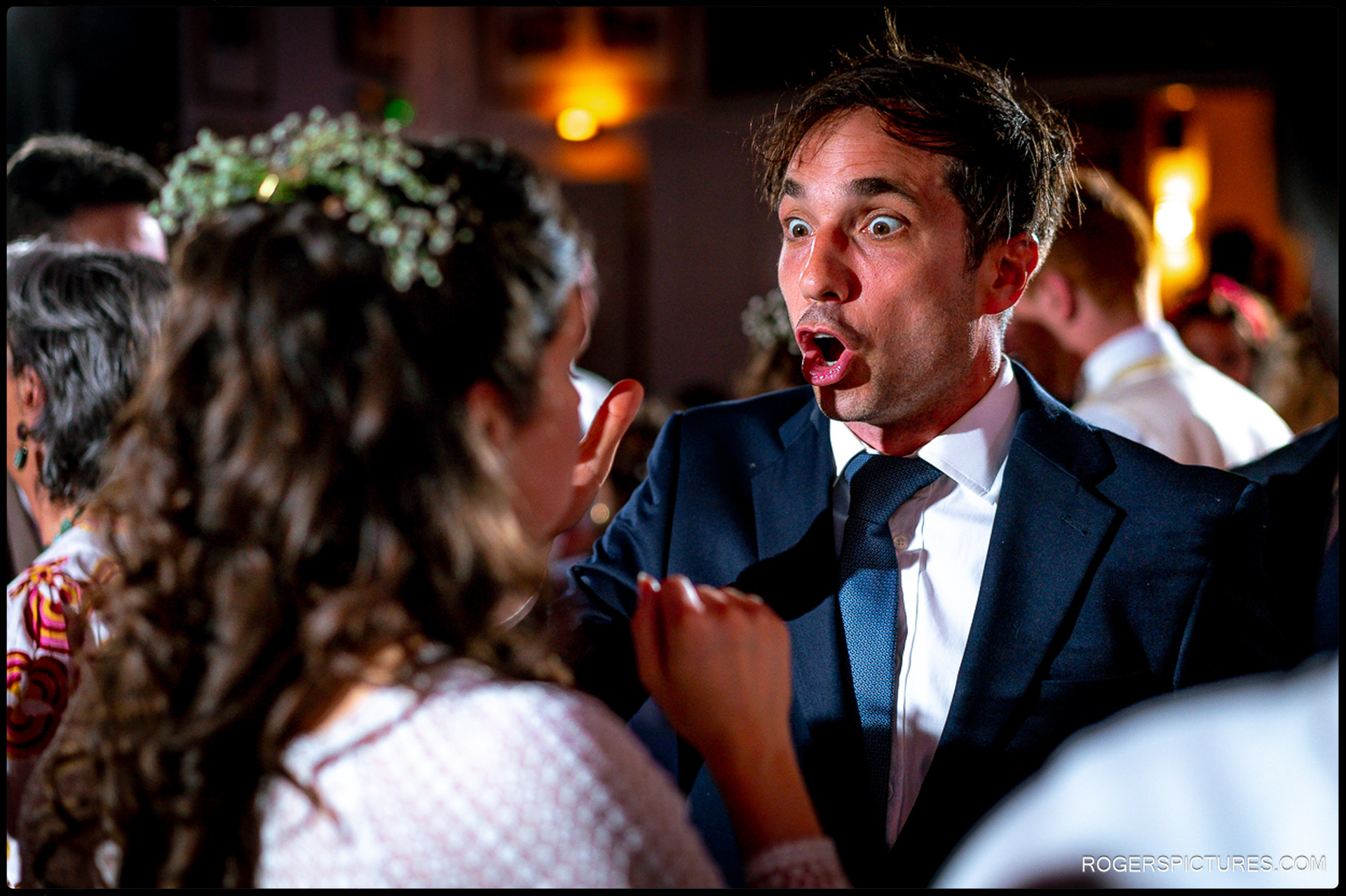 Guest pulling a playful expression while dancing with the bride during the party.