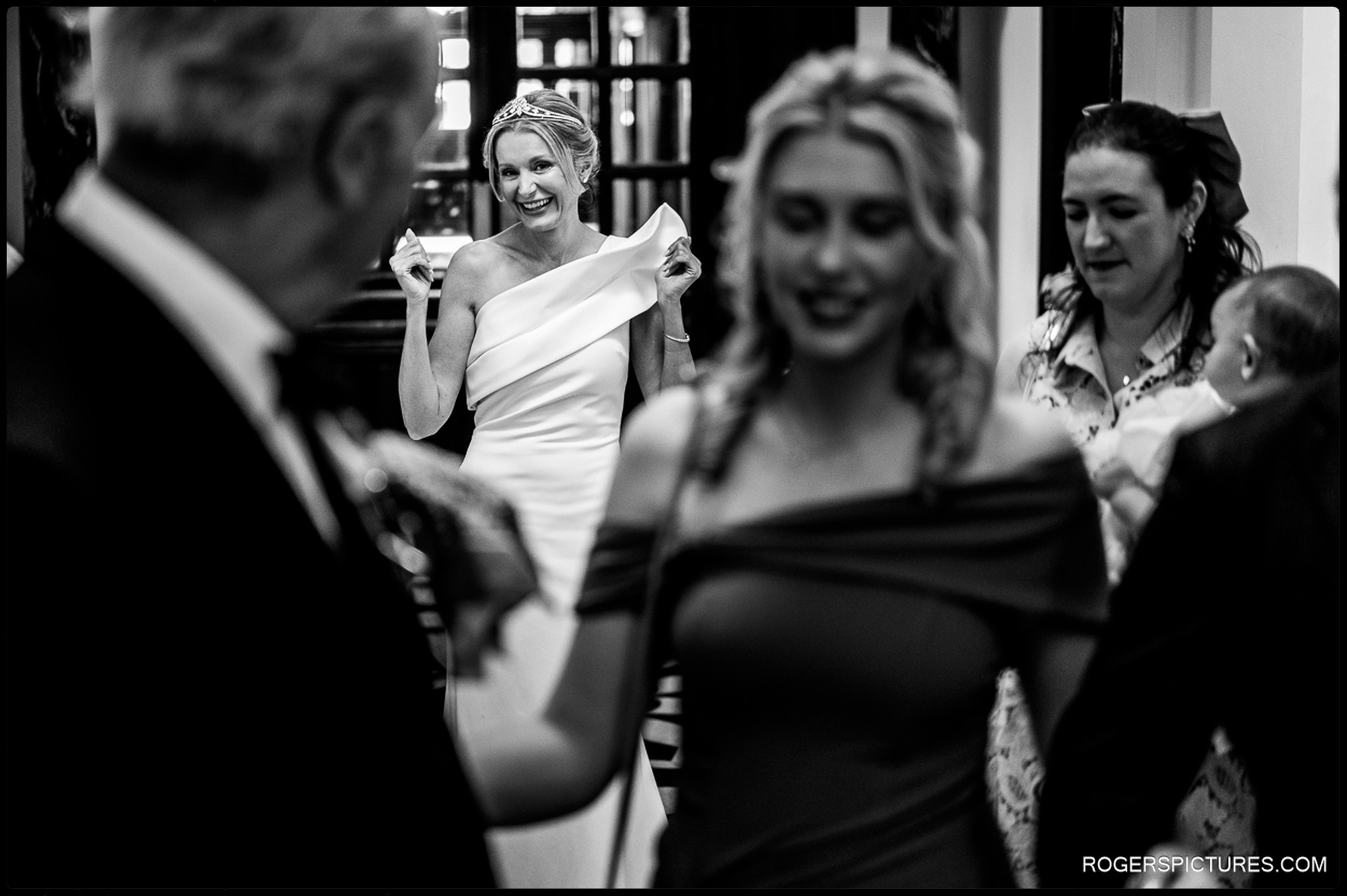 Bride smiling as she greets family and friends in the entrance hall of Chelsea Old Town Hall before the ceremony begins.