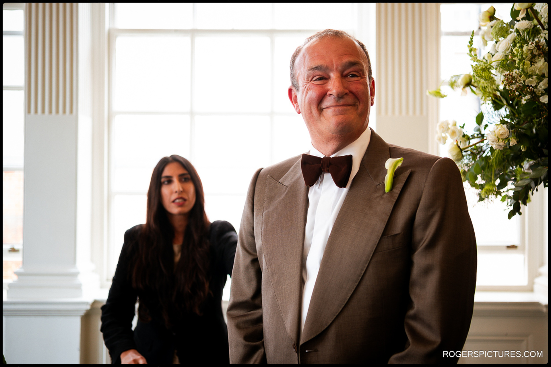 Groom standing at the front of the ceremony room at Chelsea Old Town Hall, smiling warmly as he waits for the bride’s arrival.
