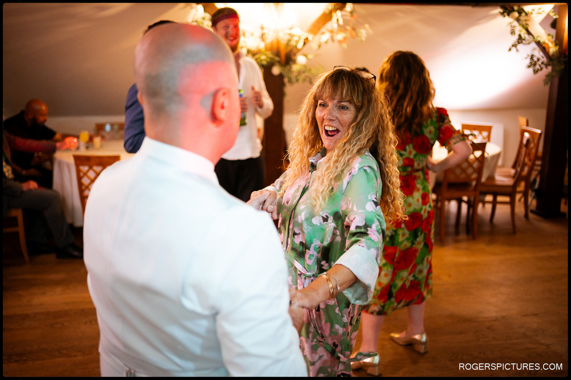 Couple dancing together on the dancefloor surrounded by cheering wedding guests at Oaks Farm
