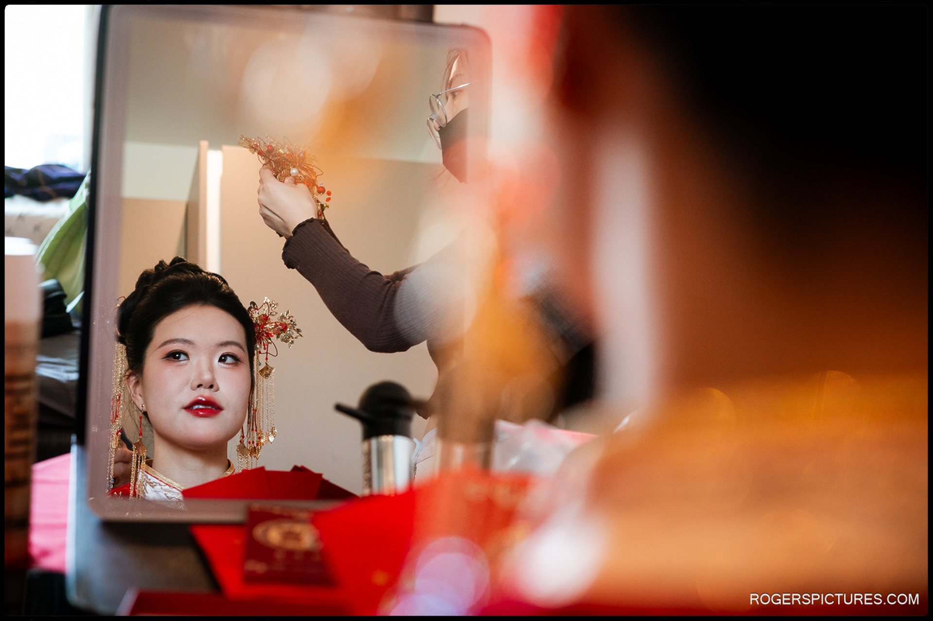 Bride’s reflection in a mirror as a hairpiece is added during her tea ceremony preparations