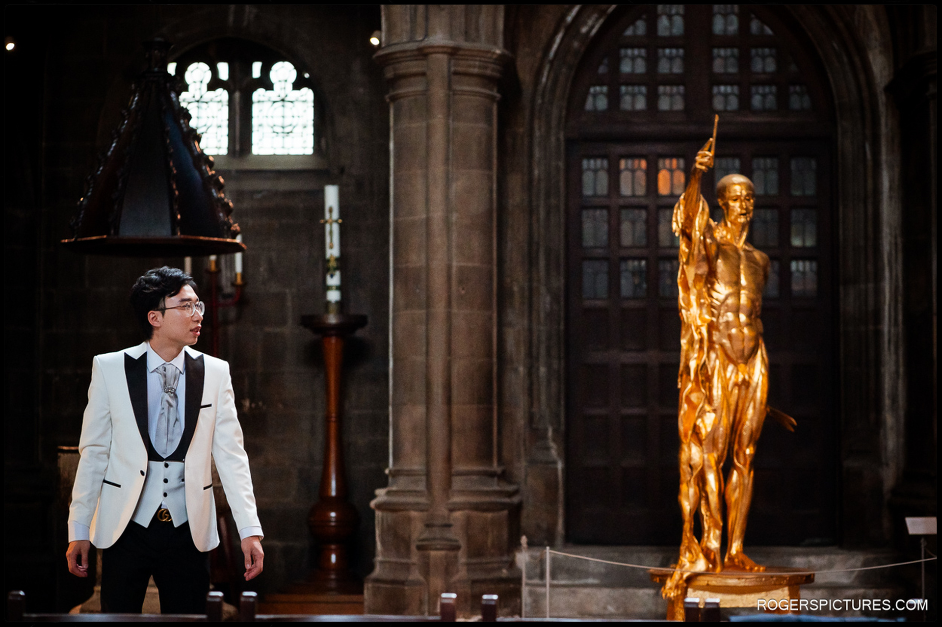 Groom standing inside St Bartholomew the Great, looking across the church interior