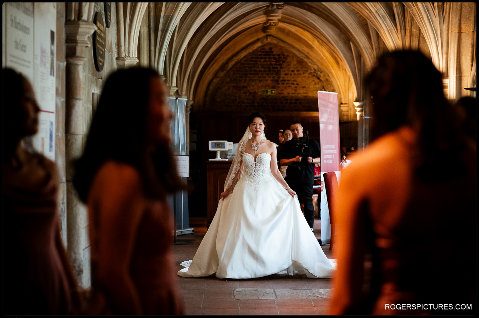 Bride walking through the cloisters at St Bartholomew the Great before the ceremony