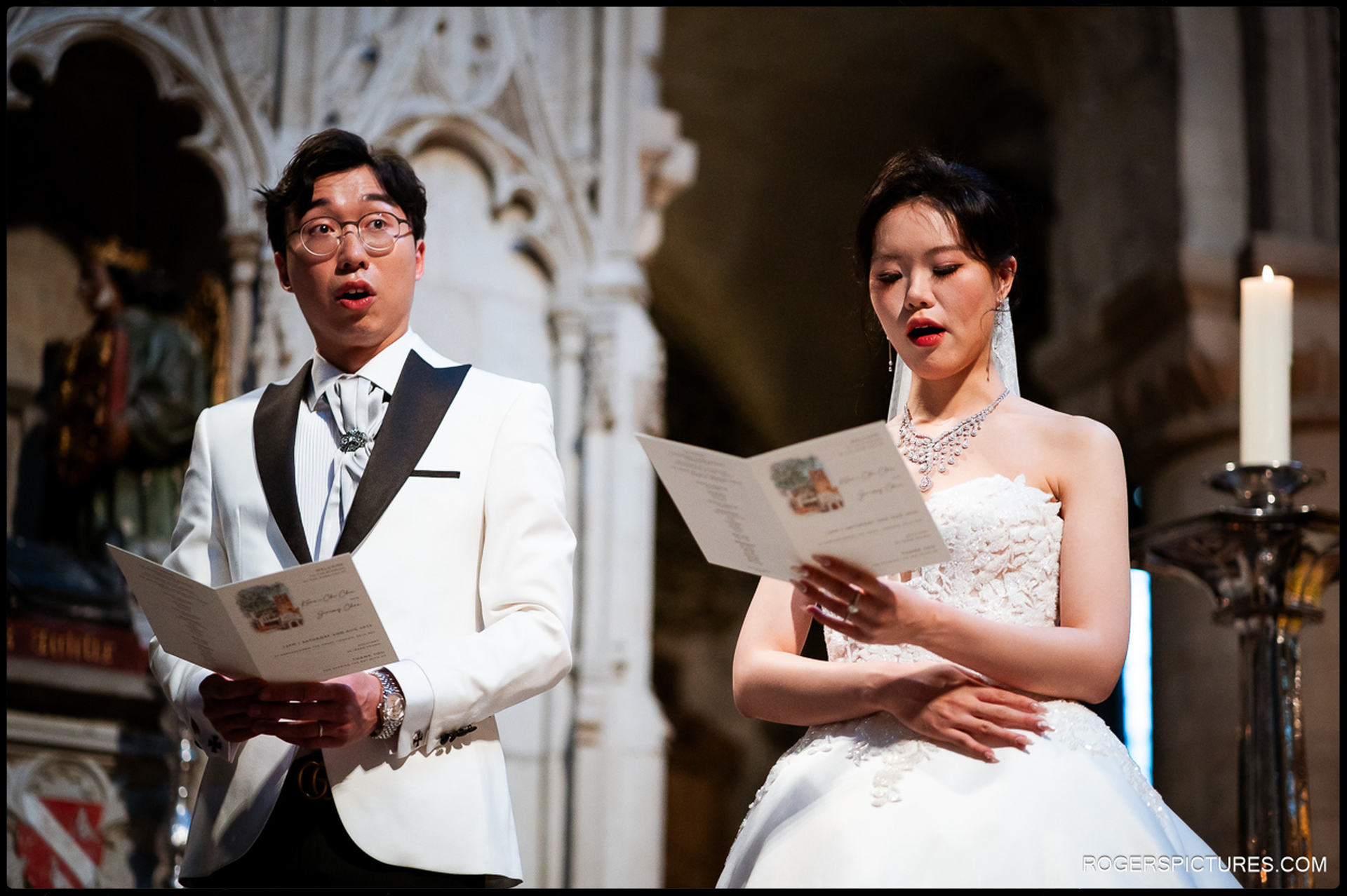 Bride and groom singing from their order of service during the ceremony
