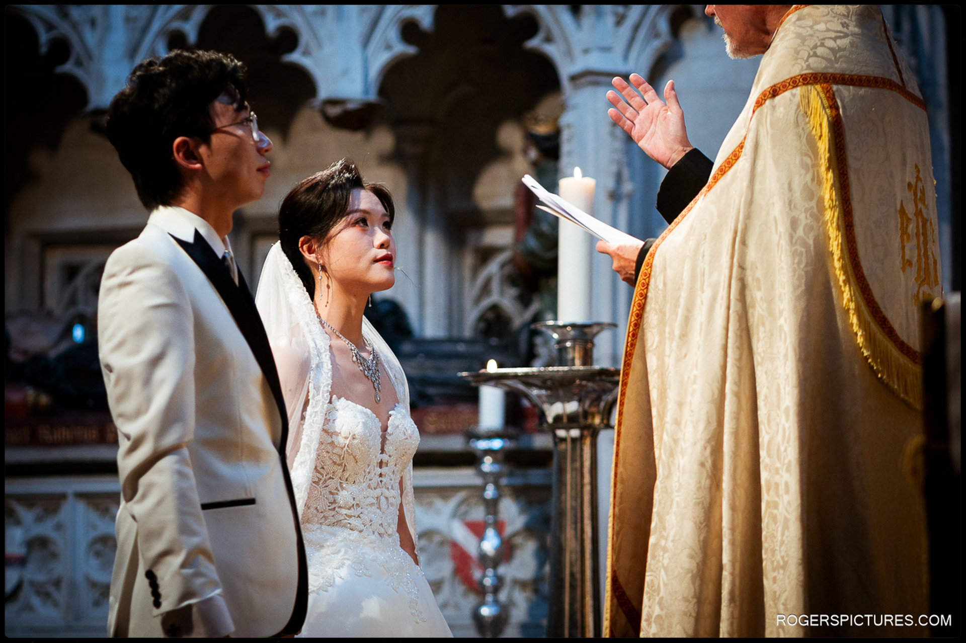 Bride looking up at the priest while standing with the groom at the altar