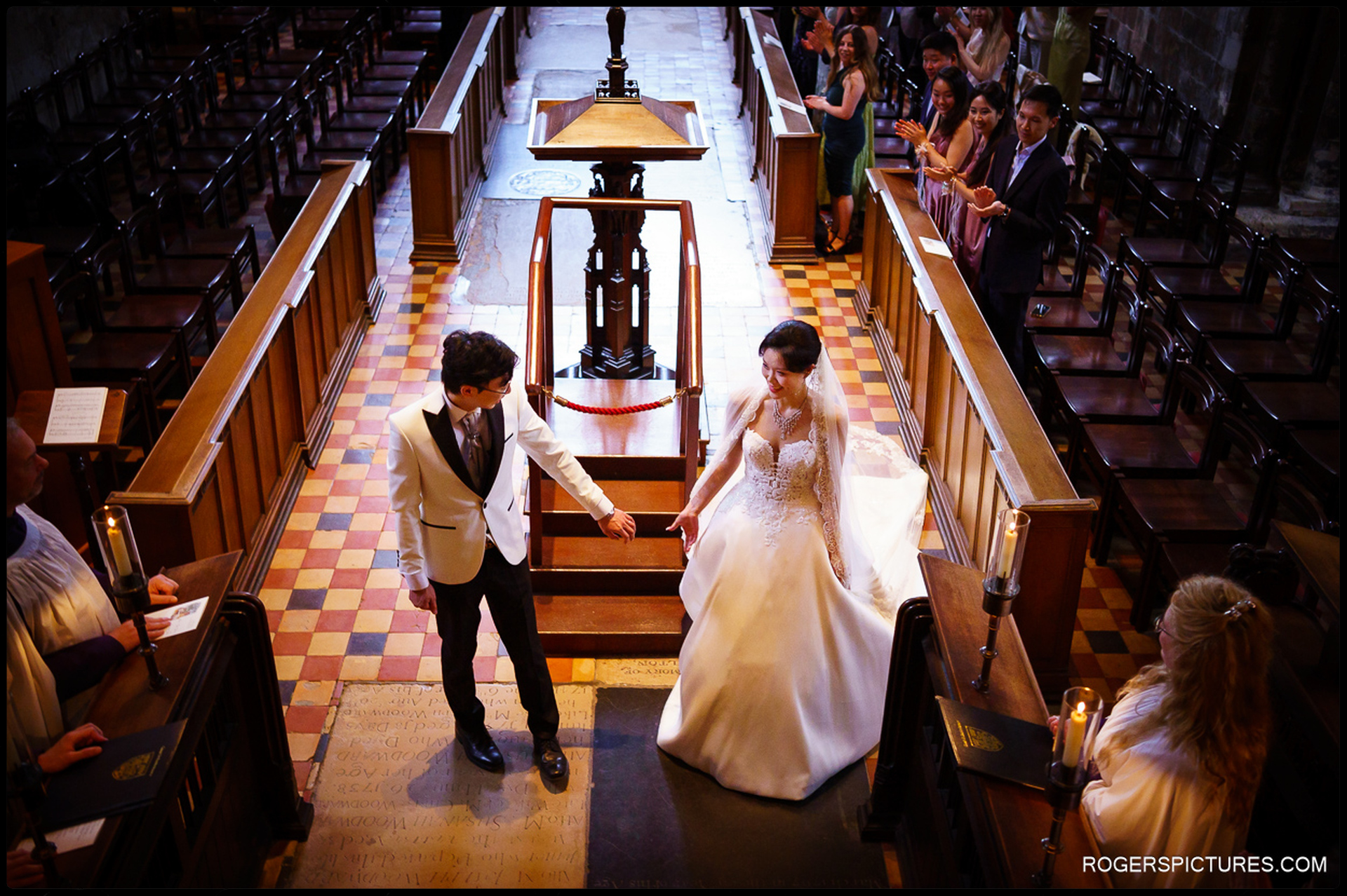 Bride and groom reaching for each other’s hands as they exit the ceremony aisle