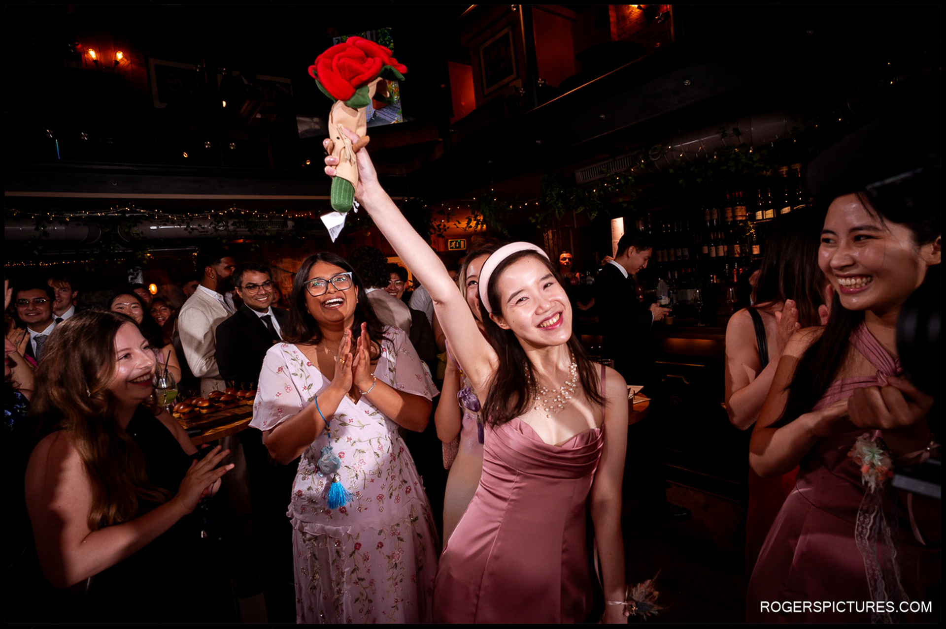 Guest holding up a playful rose bouquet during the celebrations