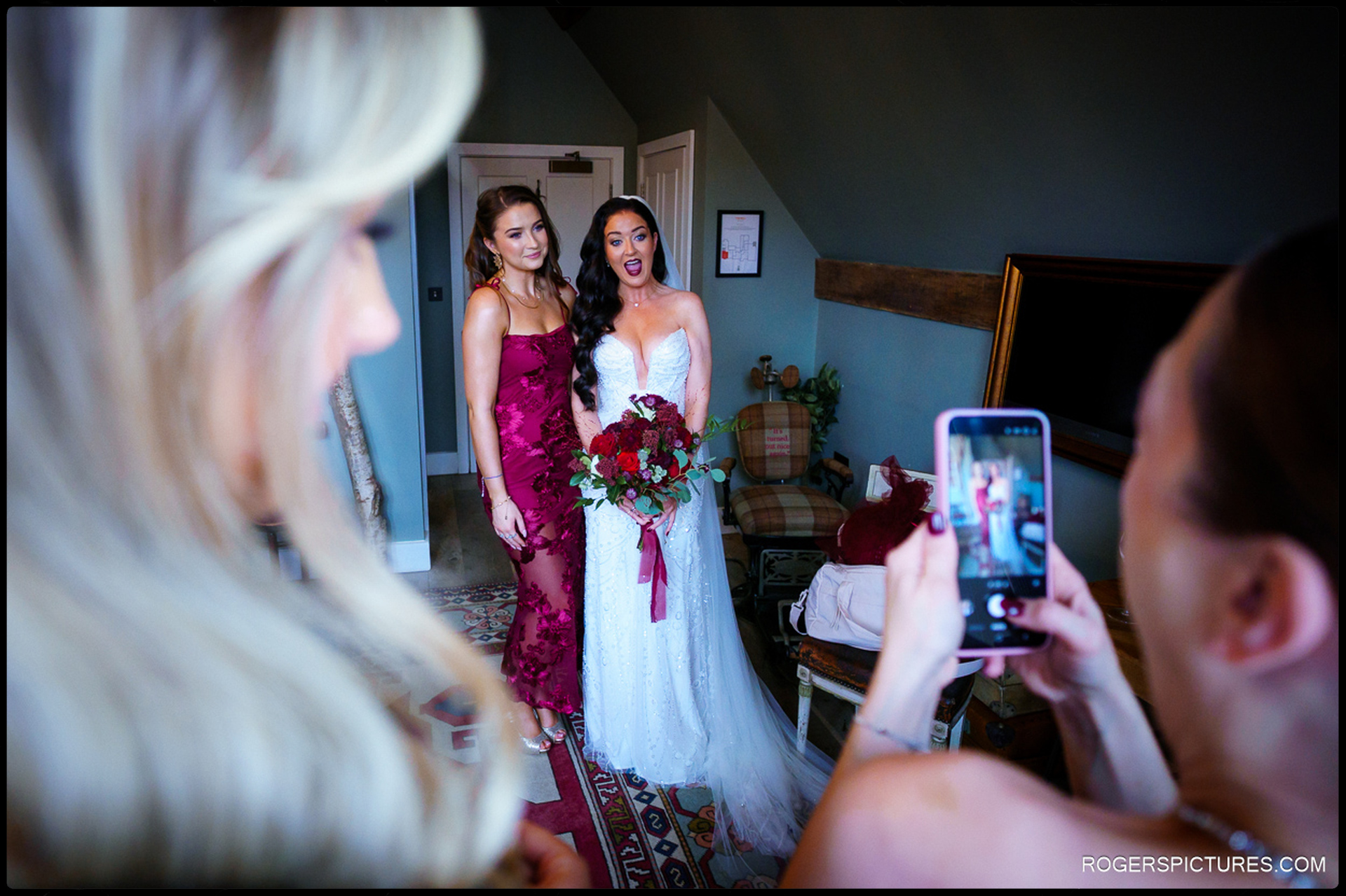 Bride Ciara and a bridesmaid posing for a mobile phone picture, capturing the fun and spontaneous moments during preparation for the wedding ceremony.