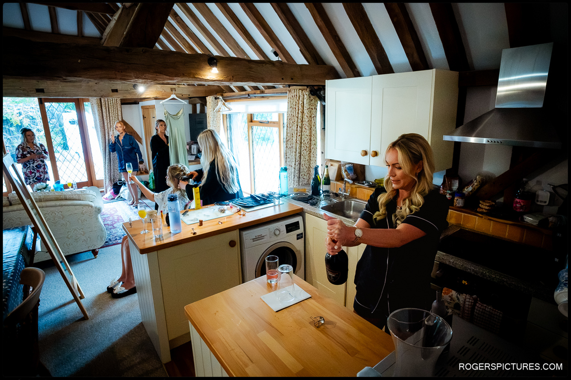 Bridesmaids and hair stylist preparing in the cottage at Rumbolds Farm before the wedding ceremony.