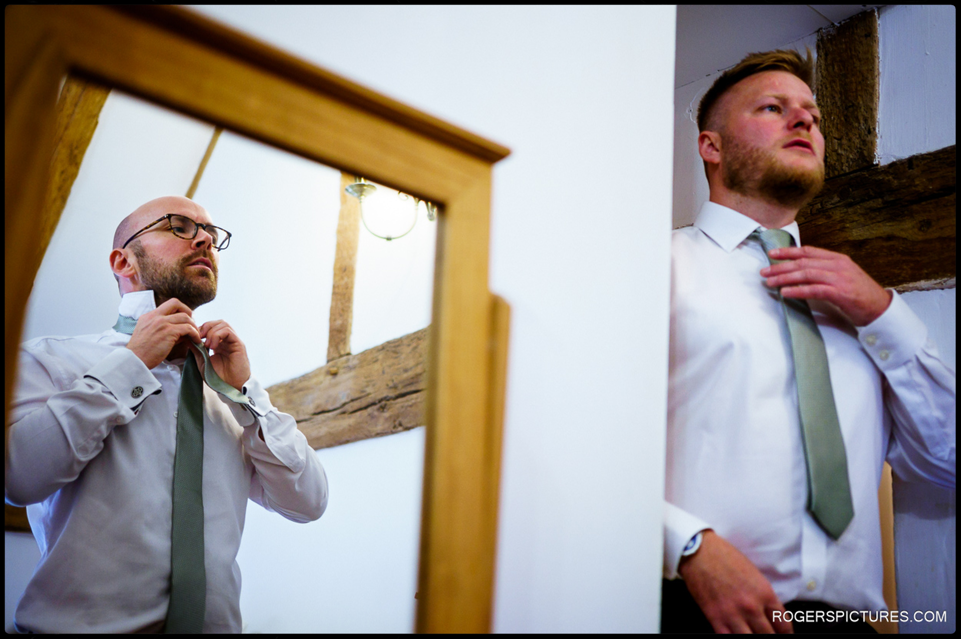 Groomsmen adjusting ties while getting ready in the barn at Rumbolds Farm.