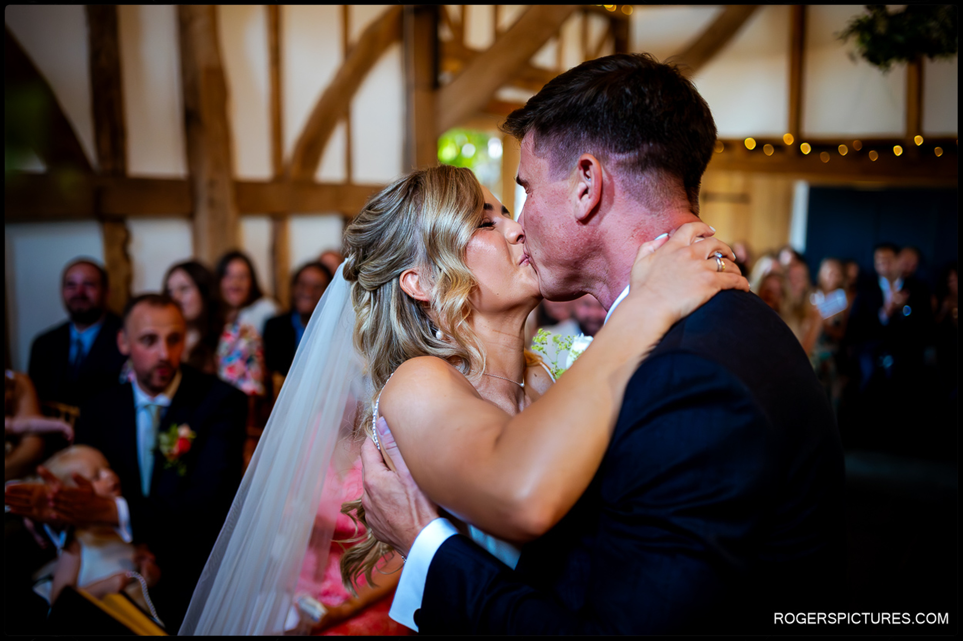 Bride and groom sharing their first kiss during the ceremony at Rumbolds Farm.
