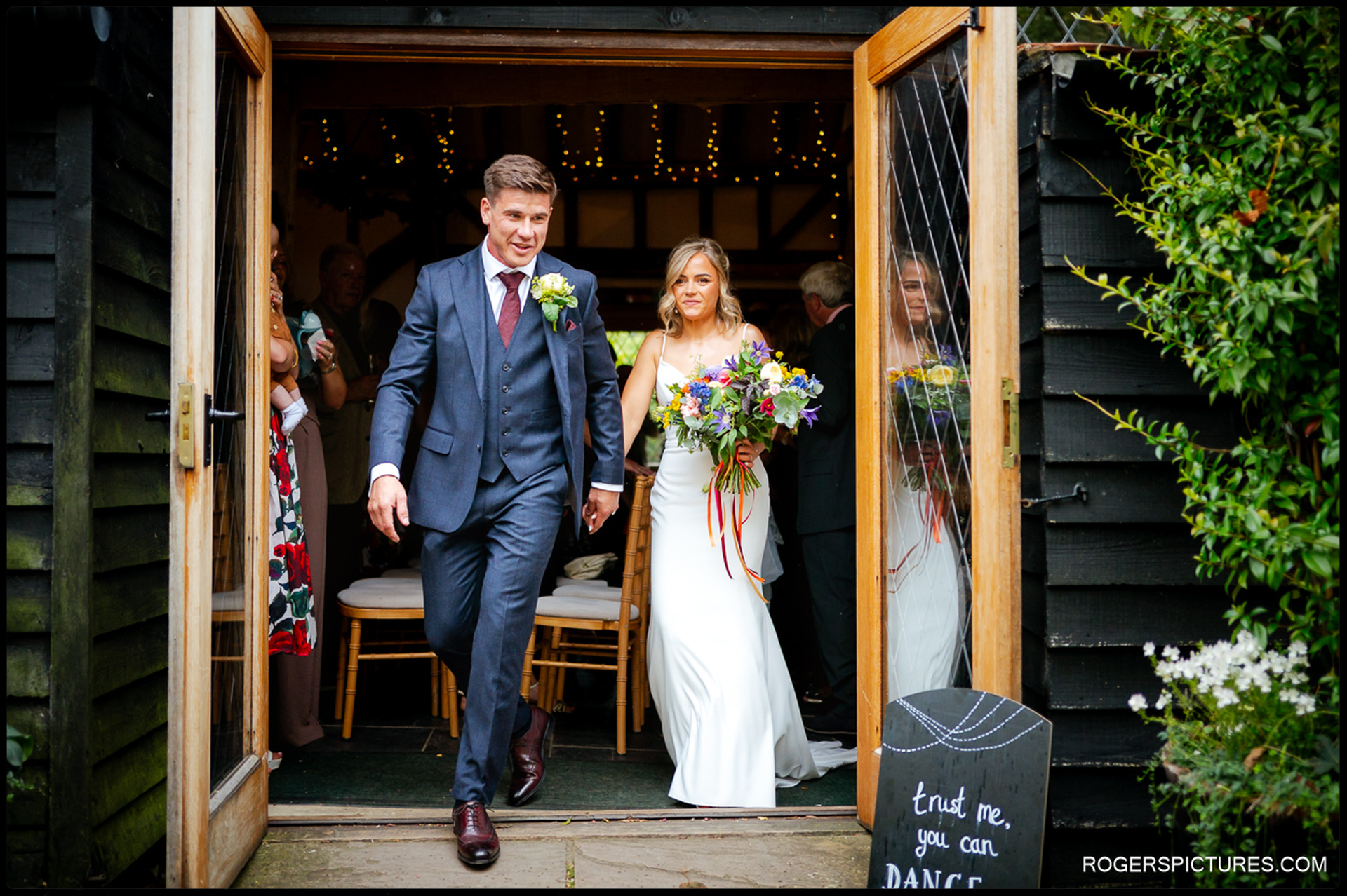 Newlyweds walking out of the barn together after the ceremony at Rumbolds Farm.