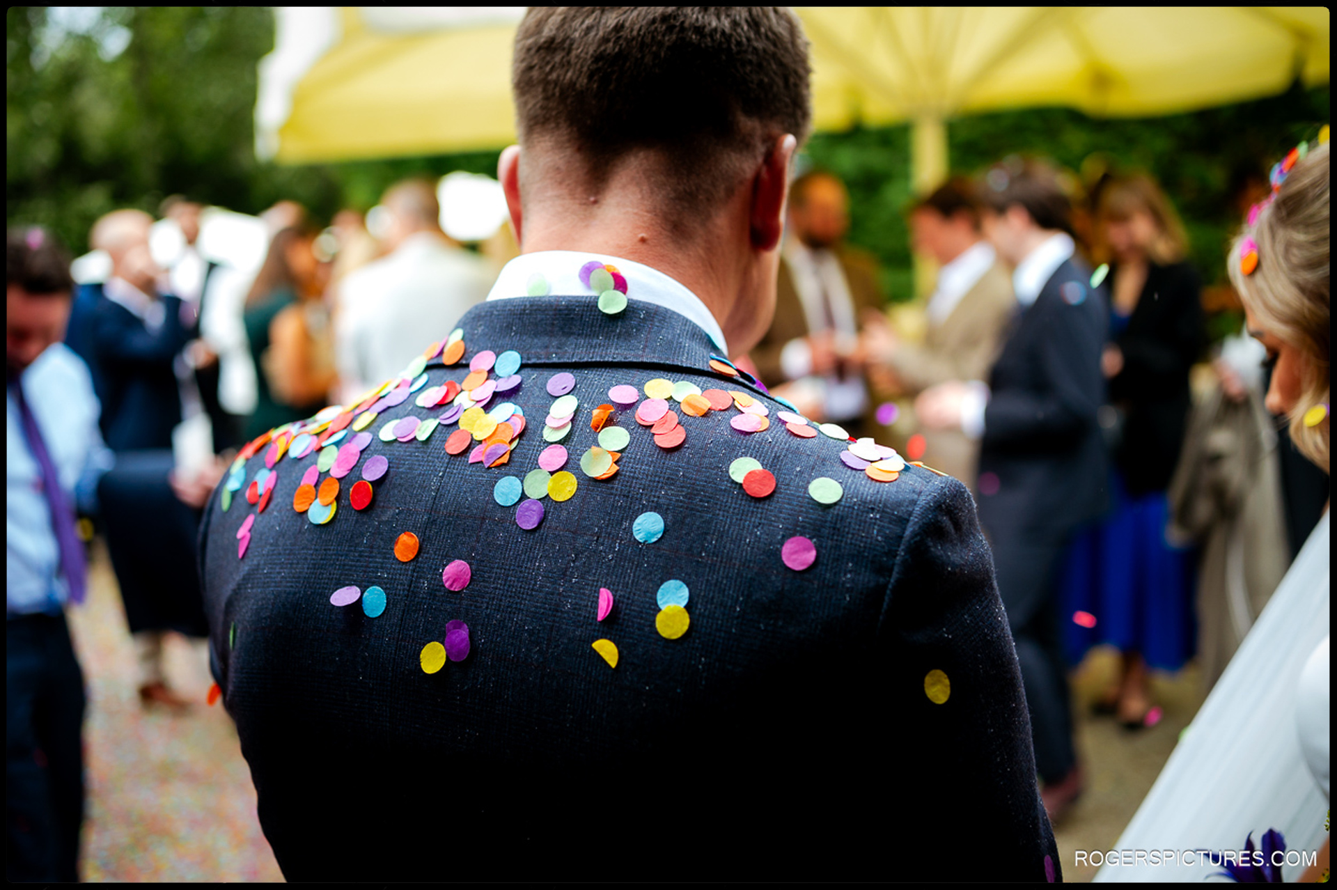 Close-up of the groom’s suit covered in confetti after the ceremony at Rumbolds Farm.