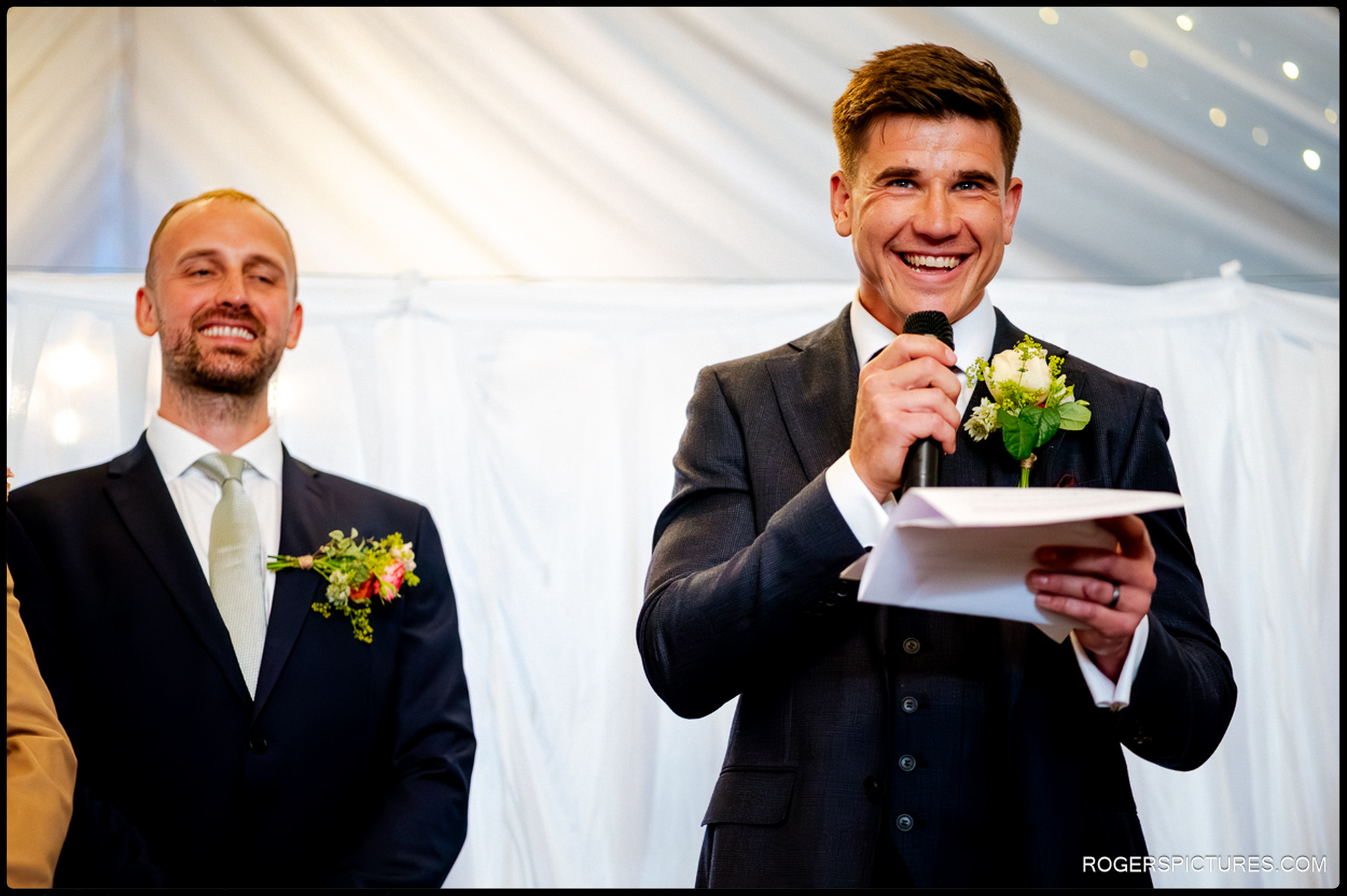 Groom giving his speech with a smile while guests look on at Rumbolds Farm.