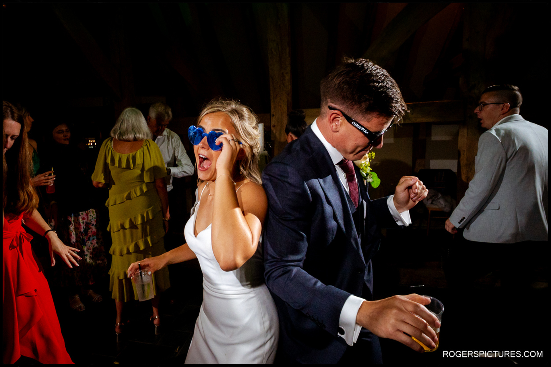 Bride and groom dancing together wearing novelty sunglasses during the evening party at Rumbolds Farm.