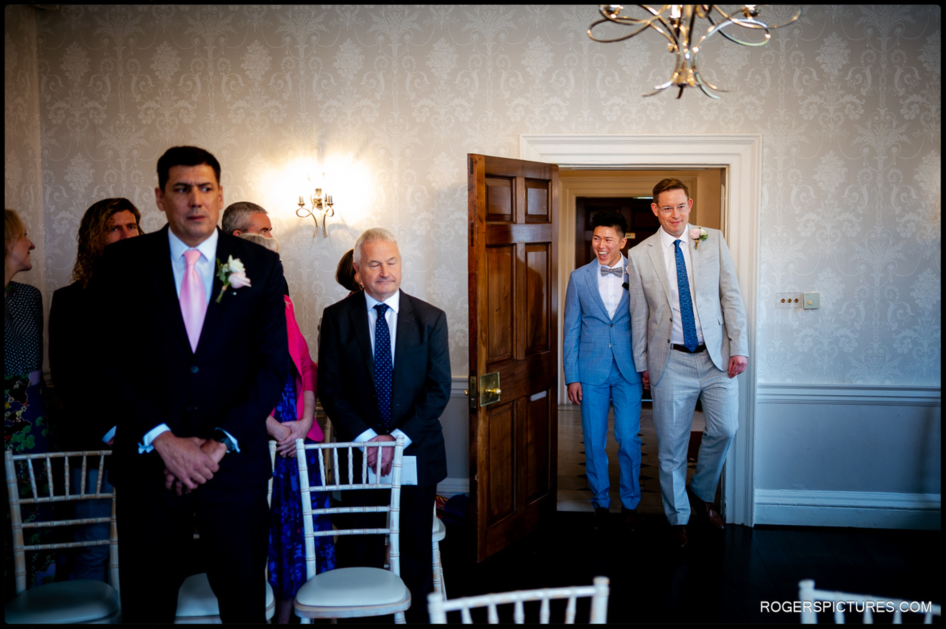 Documentary wedding photography of a couple smiling as they enter the Sheridan Room for their ceremony at Morden Park House.